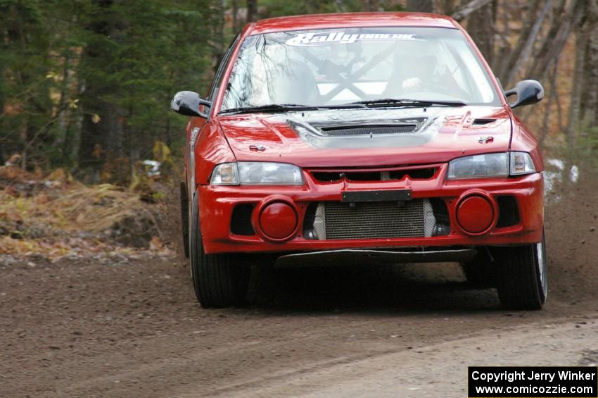 Dennis Martin / Alex Kihurani drift their Mitsubishi Lancer Evo IV around a hard left-hander near the start of SS1, Herman.