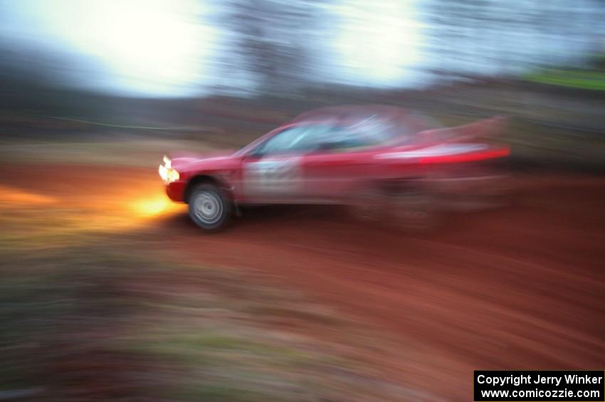 Dennis Martin / Alex Kihurani drift their Mitsubishi Lancer Evo IV around a fast uphill 90-left on SS3, Echo Lake 1.