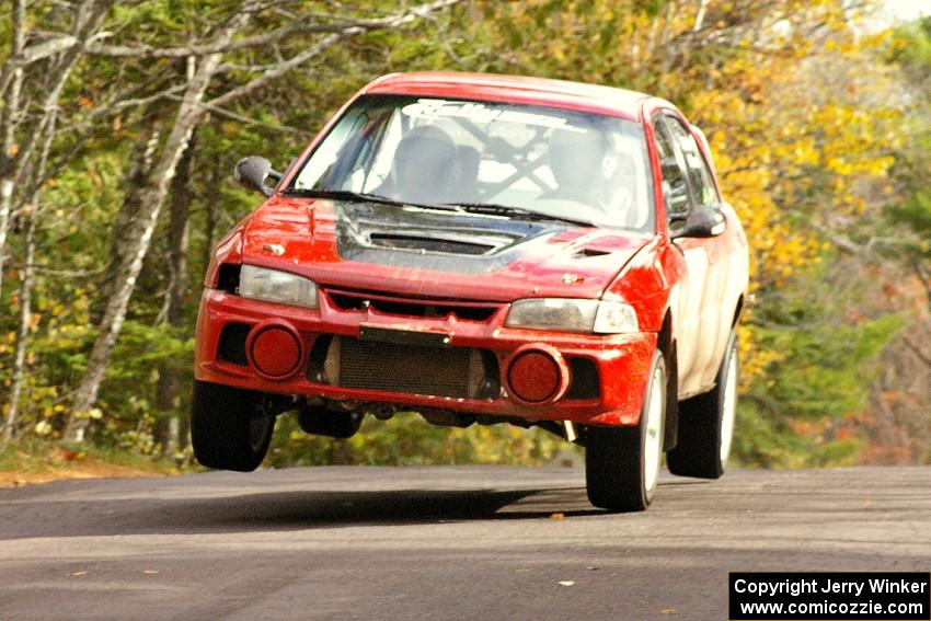 Dennis Martin / Alex Kihurani get airborne over the midpoint jump on Brockway 1, SS11, in their Mitsubishi Lancer Evo IV.