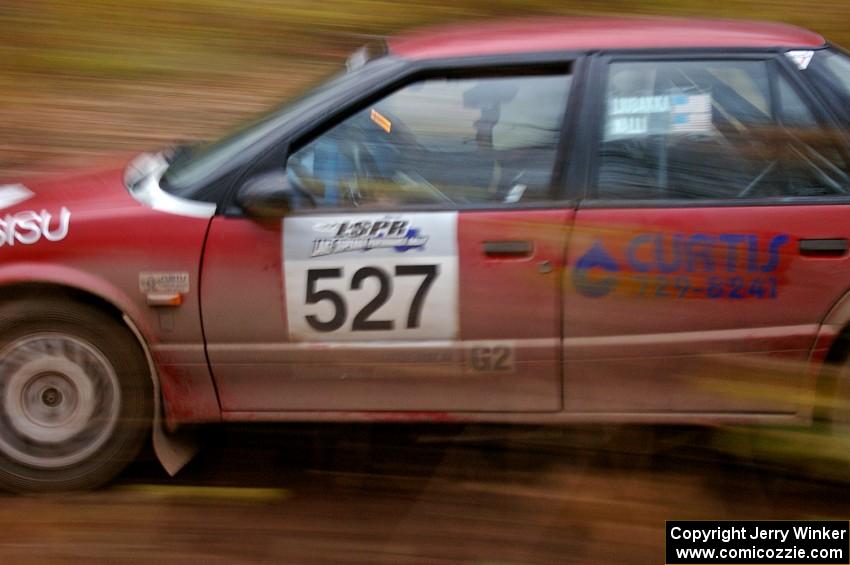 Jonah Liubakka / Craig Walli at speed through the first corner of Gratiot Lake 2, SS15, in their Saturn SL-2.